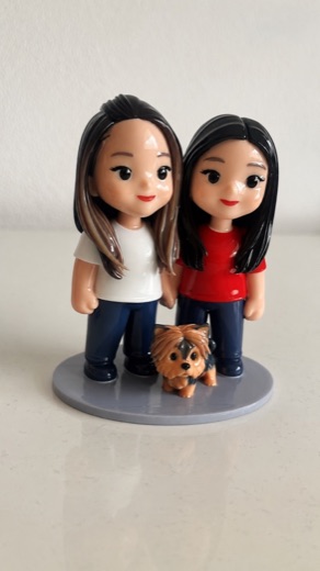 Figurine of two women holding hands with their small dog
