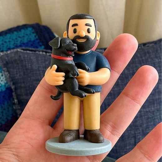 Palm-sized figurine of a bearded man holding his black labrador